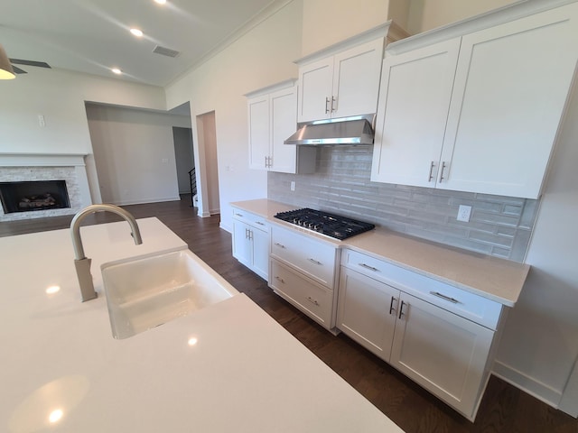 kitchen featuring sink, white cabinetry, backsplash, dark hardwood / wood-style flooring, and stainless steel gas stovetop