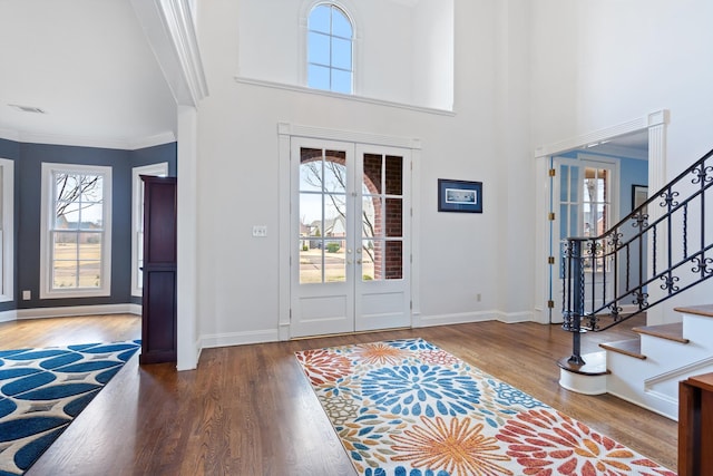 foyer entrance featuring french doors, crown molding, a high ceiling, and hardwood / wood-style flooring