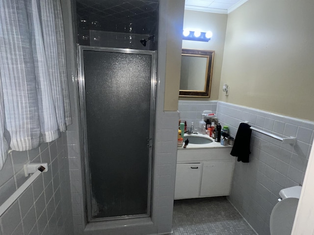 bathroom featuring crown molding, tile patterned flooring, tile walls, vanity, and an enclosed shower