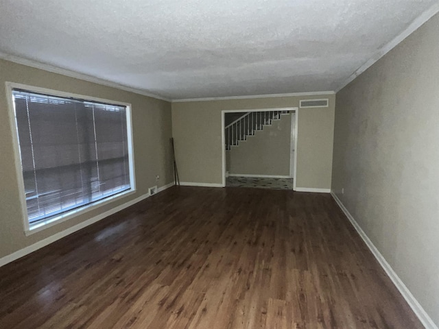 interior space featuring ornamental molding, dark wood-type flooring, and a textured ceiling