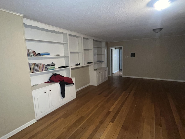 empty room with dark wood-type flooring and a textured ceiling