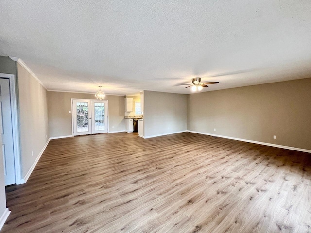 unfurnished living room with ceiling fan, a textured ceiling, and light hardwood / wood-style floors