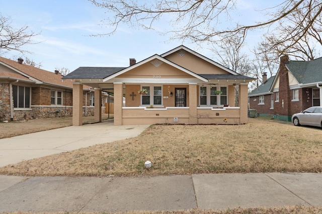 bungalow featuring a carport, covered porch, and a front lawn