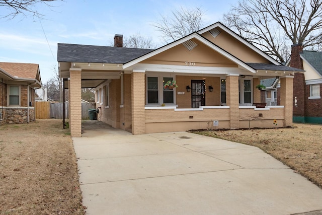 bungalow-style house featuring a front lawn, a carport, and covered porch