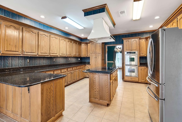 kitchen with visible vents, light tile patterned floors, appliances with stainless steel finishes, a peninsula, and island exhaust hood