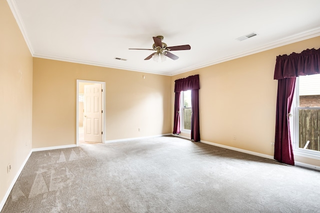carpeted empty room featuring ornamental molding, visible vents, baseboards, and a ceiling fan