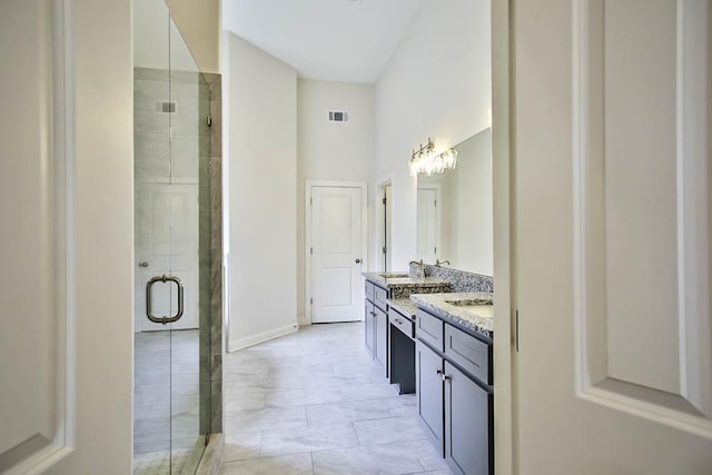 bathroom with a high ceiling, vanity, and an enclosed shower