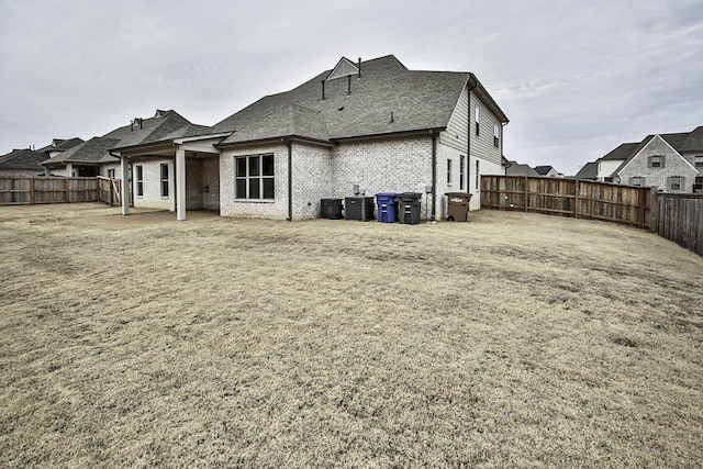 back of house with cooling unit and a lawn