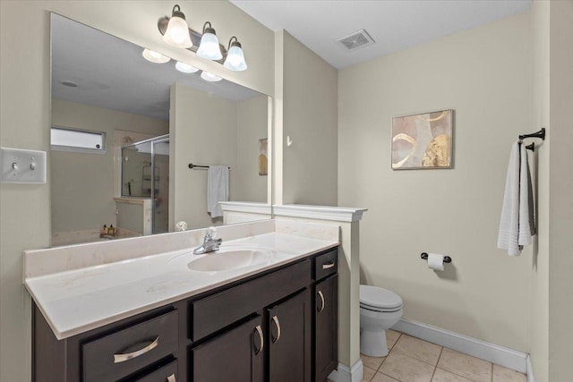 bathroom featuring vanity, tile patterned floors, toilet, and walk in shower