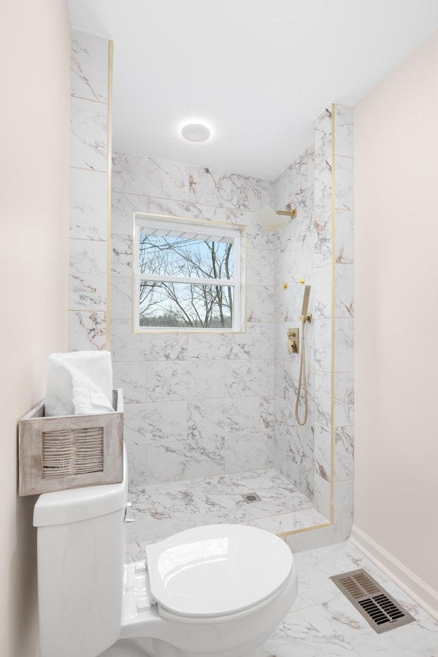 bathroom featuring toilet and a tile shower