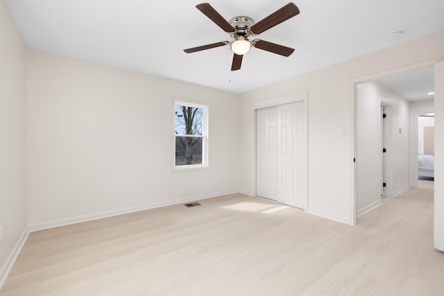 unfurnished bedroom with ceiling fan, light wood-type flooring, and a closet