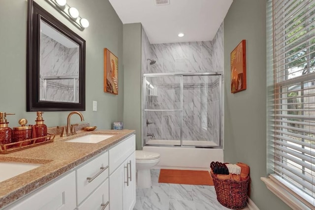 full bathroom with vanity, shower / bath combination with glass door, and toilet