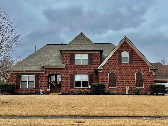 view of property featuring french doors and a front lawn