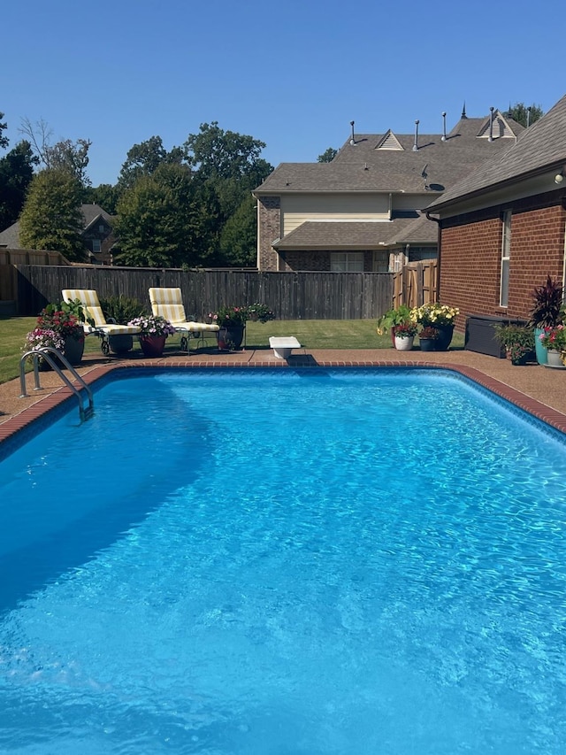 view of swimming pool featuring a diving board