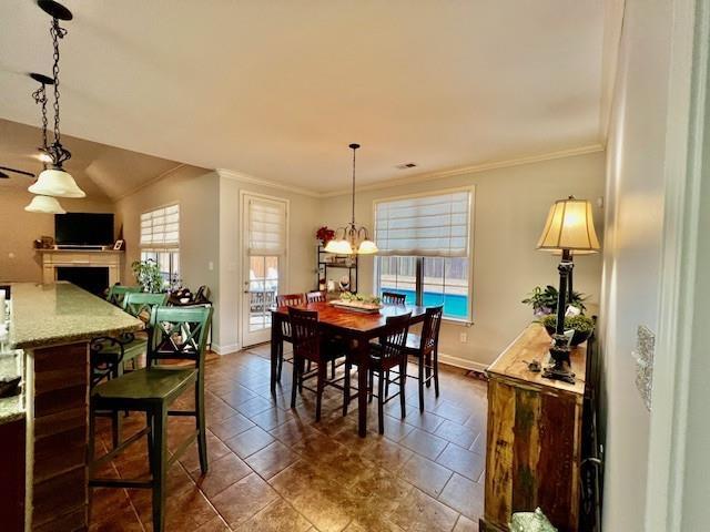 dining area with crown molding, a healthy amount of sunlight, and a chandelier