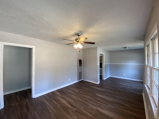 unfurnished room with a textured ceiling, dark hardwood / wood-style floors, and ceiling fan