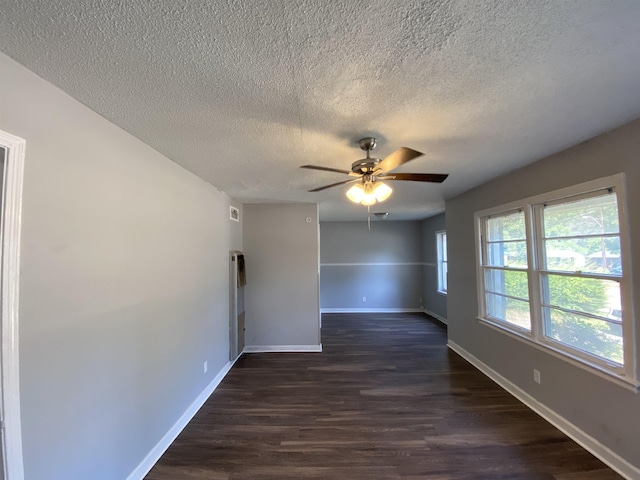 empty room featuring a textured ceiling, dark hardwood / wood-style floors, and ceiling fan