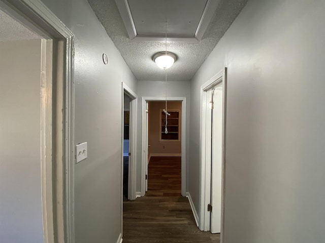 corridor featuring dark hardwood / wood-style floors and a textured ceiling