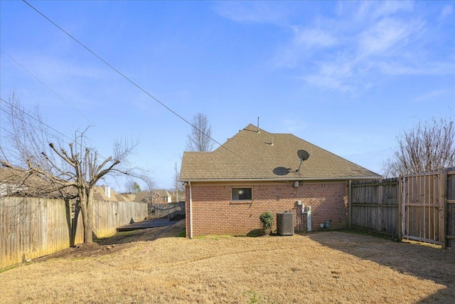 back of property featuring a yard and central air condition unit