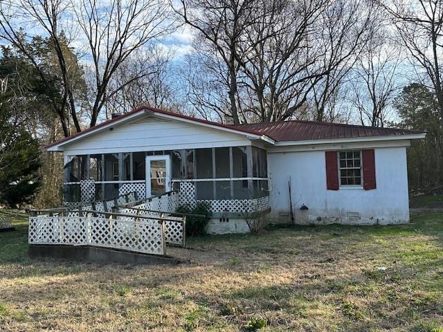 view of front of property with a sunroom and a front yard