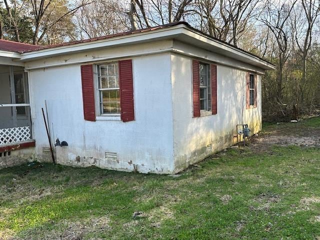 view of side of home featuring a lawn