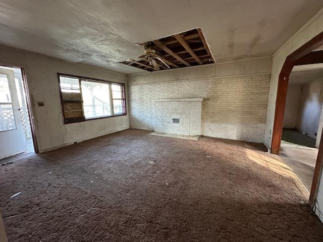 unfurnished living room with brick wall