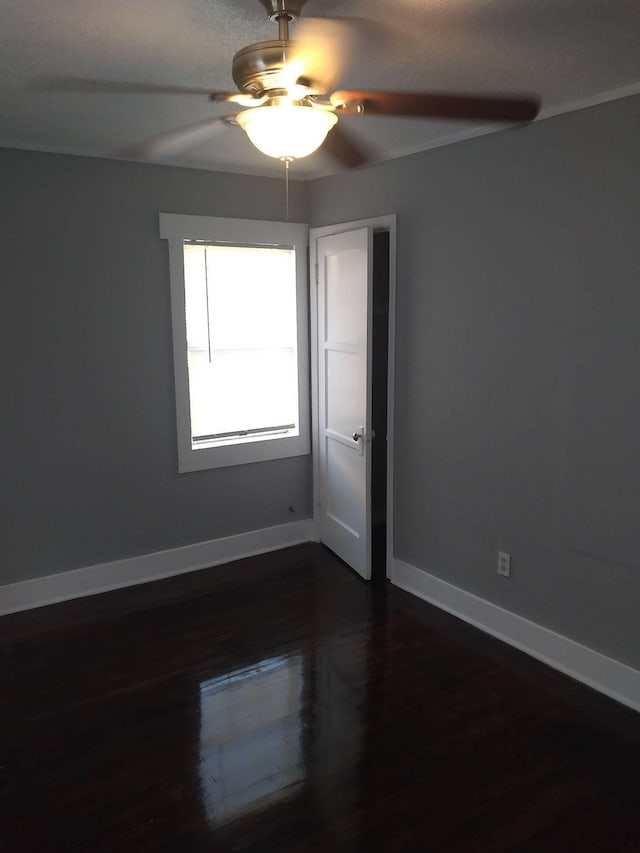 spare room featuring ceiling fan and dark hardwood / wood-style flooring