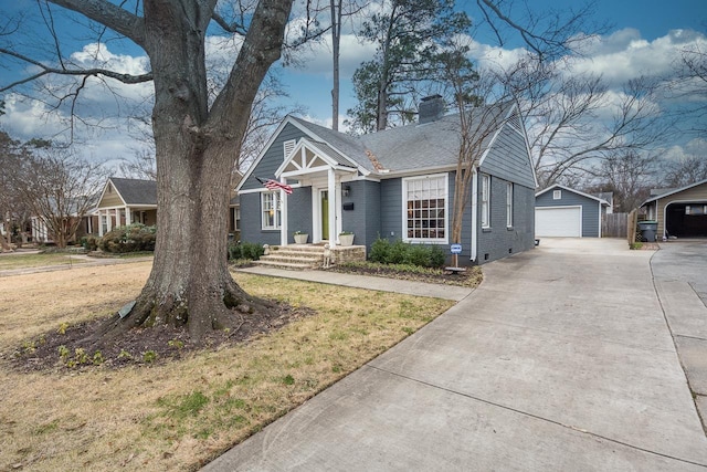 view of front of home featuring an outbuilding, a front yard, and a garage