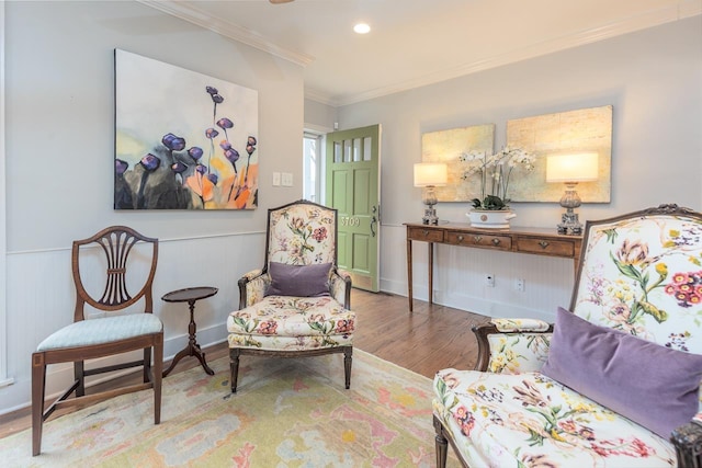 living area featuring hardwood / wood-style floors and crown molding