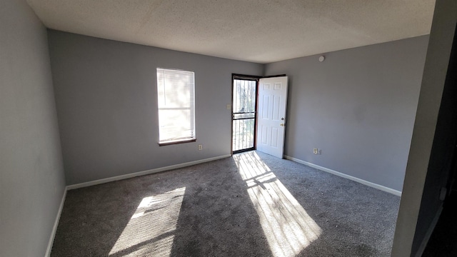 carpeted spare room featuring a textured ceiling