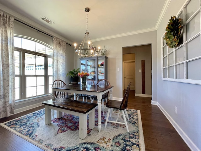 dining room featuring crown molding, dark wood-type flooring, and a chandelier