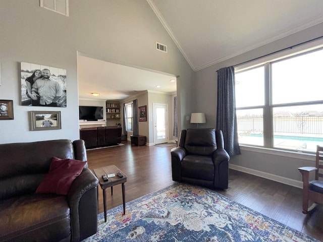 living room with hardwood / wood-style flooring, ornamental molding, and high vaulted ceiling