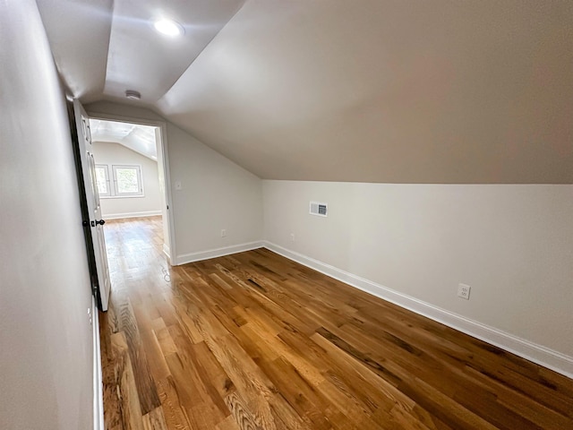 bonus room with vaulted ceiling and wood-type flooring