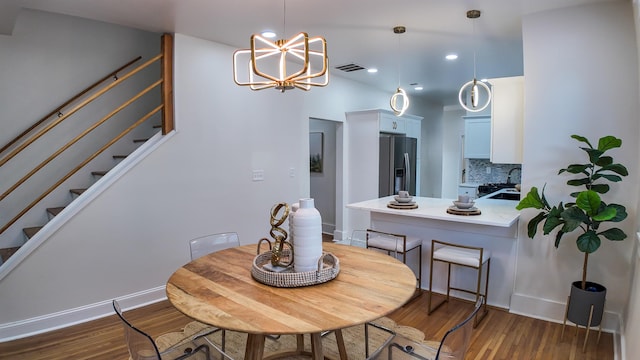 dining space with dark hardwood / wood-style flooring, sink, and a chandelier