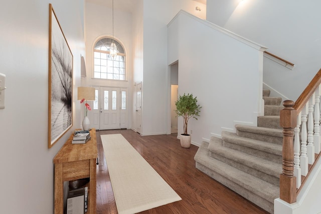 entryway with dark wood-type flooring and a high ceiling