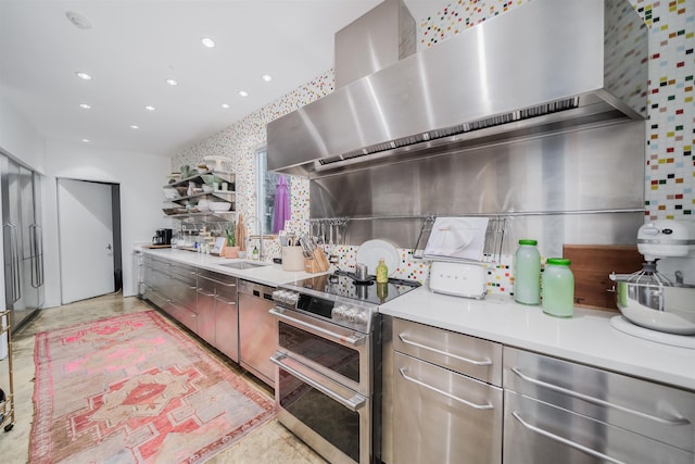 kitchen with wall chimney range hood, appliances with stainless steel finishes, and sink