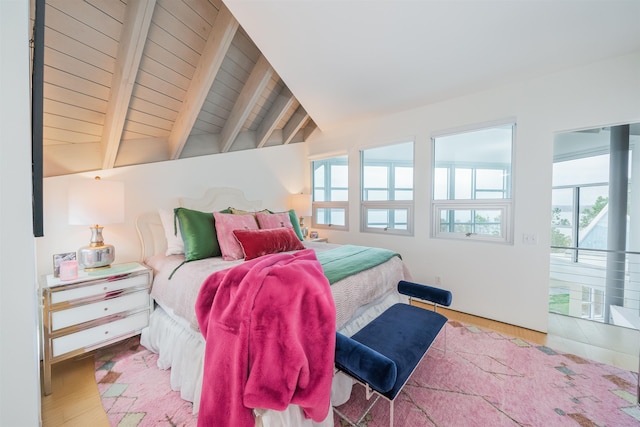 bedroom featuring multiple windows, vaulted ceiling with beams, access to outside, and light hardwood / wood-style floors