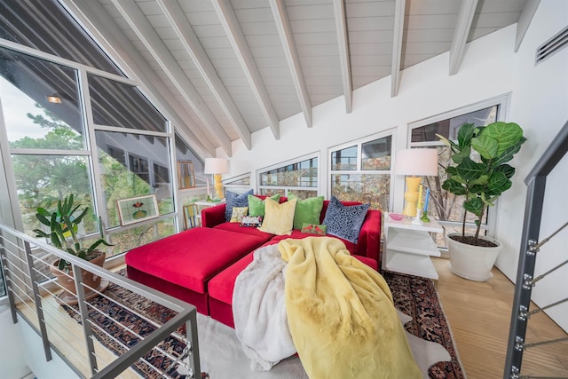 sunroom featuring vaulted ceiling with beams