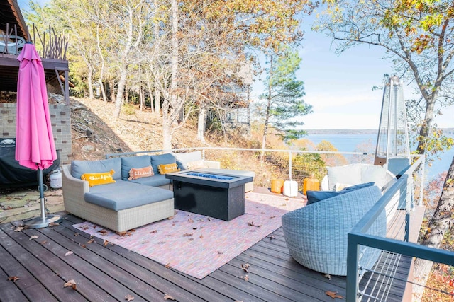 wooden terrace with a water view and an outdoor living space with a fire pit