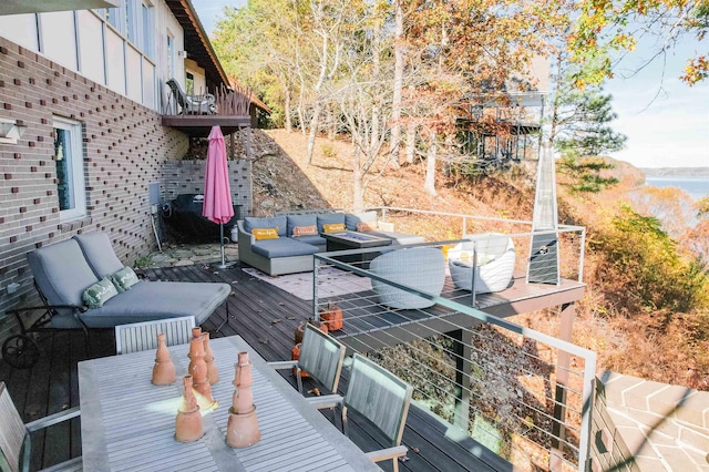 wooden deck featuring an outdoor living space with a fire pit