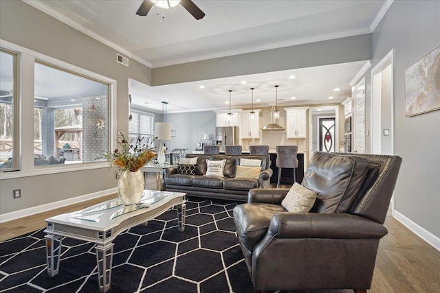 living room featuring ceiling fan, hardwood / wood-style flooring, and crown molding