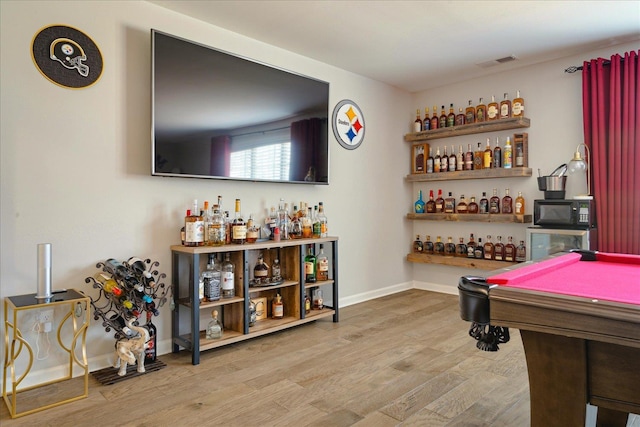 recreation room with light wood-type flooring, pool table, and indoor bar