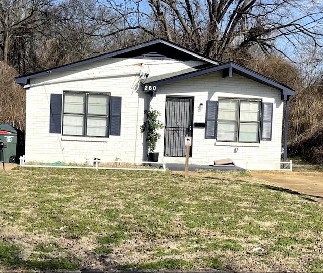 bungalow-style home with a front lawn