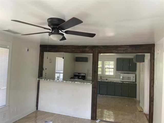 kitchen with kitchen peninsula, light stone countertops, and electric range