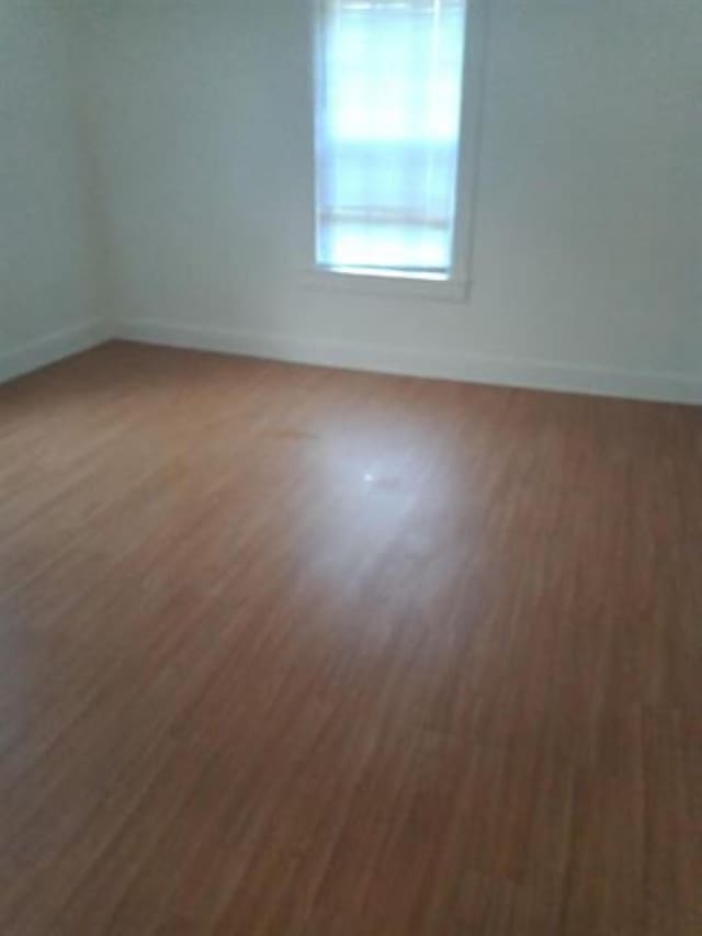 unfurnished room with dark hardwood / wood-style flooring