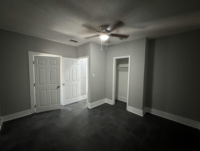 unfurnished bedroom featuring ceiling fan, a textured ceiling, and a closet