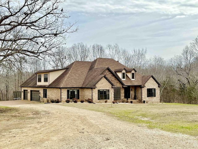 view of front of property featuring a garage, brick siding, driveway, and a front lawn