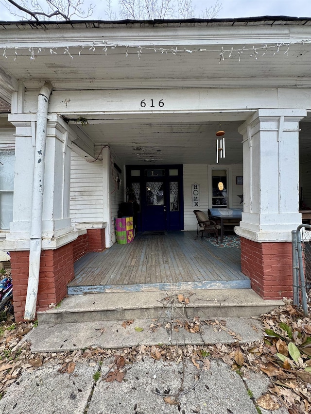 view of exterior entry featuring covered porch