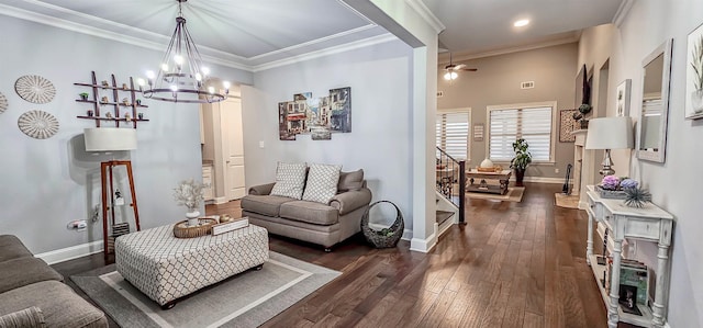 living room featuring ceiling fan with notable chandelier, ornamental molding, and dark wood-type flooring