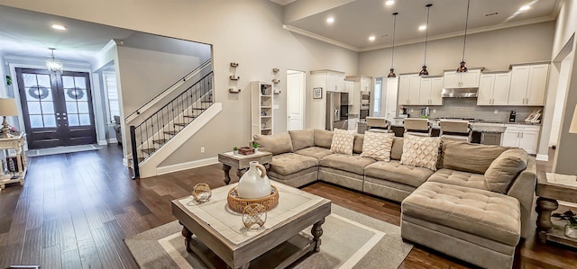 living room featuring ornamental molding, dark wood-type flooring, and a high ceiling